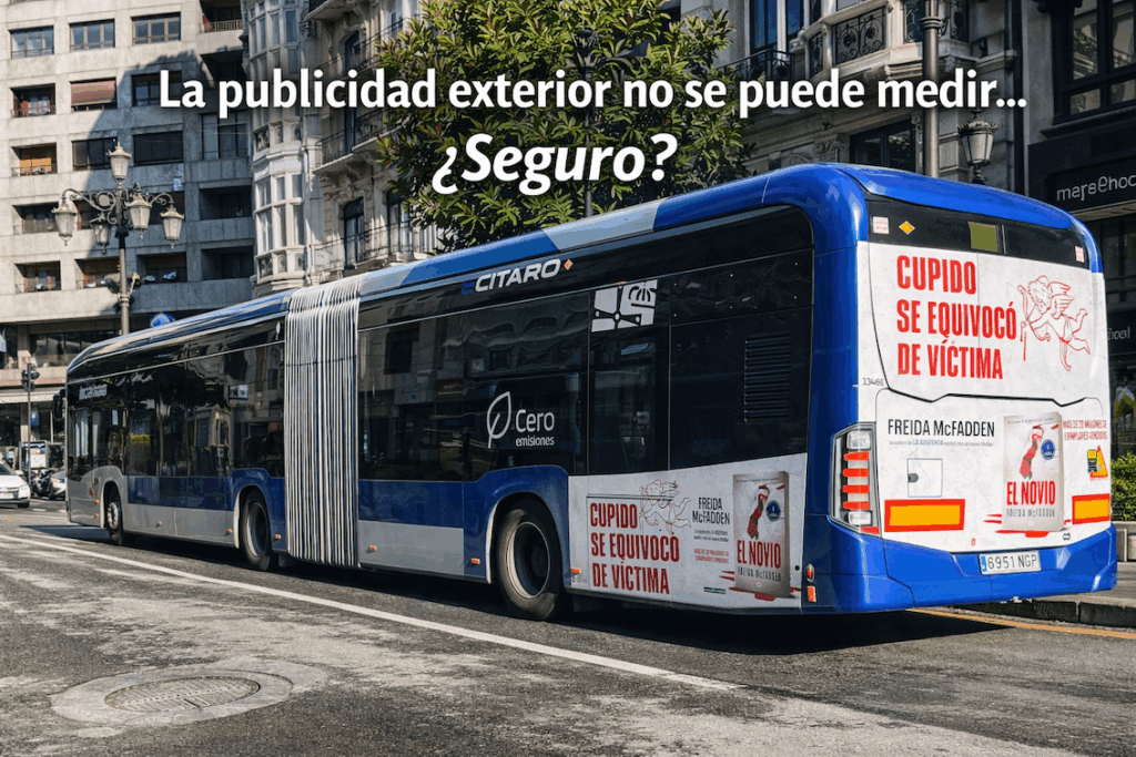Autobús urbano eléctrico en Oviedo con campaña publicitaria exterior en la trasera circulando por el centro de la ciudad