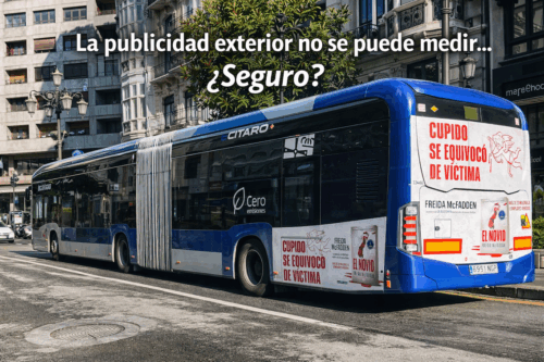 Autobús urbano eléctrico en Oviedo con campaña publicitaria exterior en la trasera circulando por el centro de la ciudad