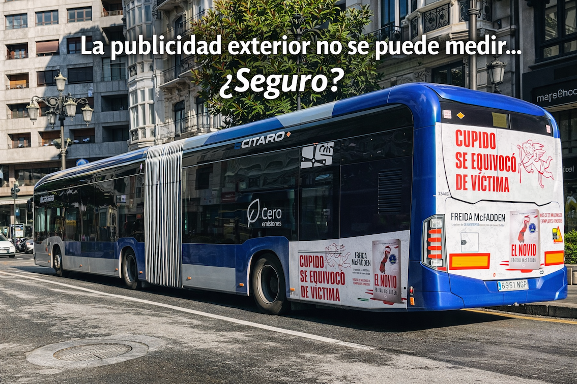 Autobús urbano eléctrico en Oviedo con campaña publicitaria exterior en la trasera circulando por el centro de la ciudad